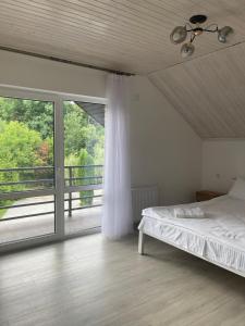 a bedroom with a bed and a large window at Goral cottage new in Migovo