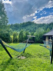 zwei Hängematten auf einem Feld mit Bäumen im Hintergrund in der Unterkunft Goral cottage new in Myhowe