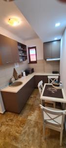 a kitchen with a sink and a table and a counter at AnaMaria Apartments Mamaia Nord in Mamaia Sat/Năvodari