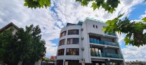 a tall white building with a sky in the background at AnaMaria Apartments Mamaia Nord in Mamaia Sat/Năvodari