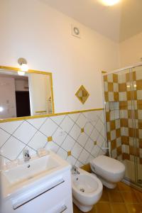 een badkamer met een wastafel, een toilet en een spiegel bij Casa Satriano 2 in Positano