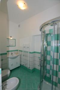 een groene en witte badkamer met een wastafel en een douche bij Casa Satriano 2 in Positano