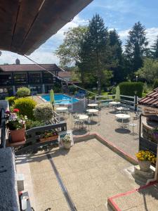 une terrasse avec des tables et des chaises ainsi qu'une piscine dans l'établissement La Vieille Ferme, à Étupes