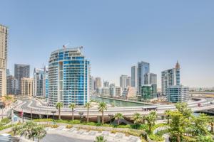 Classy 1BR at The Address Residences in JBR by Deluxe Holiday Homes في دبي: أفق المدينة مع المباني الطويلة والطريق السريع