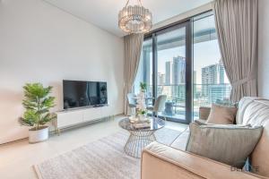 ein Wohnzimmer mit einem Sofa und einem TV in der Unterkunft Classy 1BR at The Address Residences in JBR by Deluxe Holiday Homes in Dubai