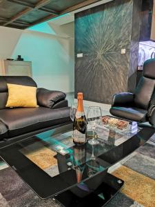 a living room with a bottle of wine on a glass table at XSpa Apartment cryptocurrency pay available in Novi Sad