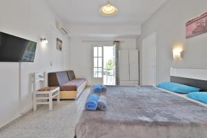 a bedroom with a large bed with blue slippers at Fotini Studios in Paleokastritsa