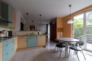 a kitchen with a table and a dining room at Vakantiehuis Salamander Maasmechelen in Maasmechelen