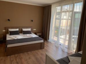 una camera da letto con un letto e una grande finestra di Guest House Smile a Kobuleti