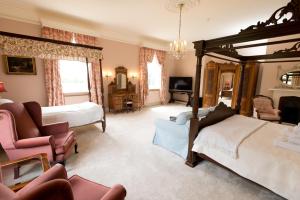 a large bedroom with a bed and a couch and chairs at Burton Court in Dilwyn