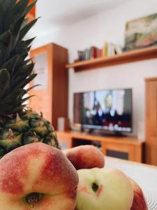 two apples and a pineapple on a table at Apartamento Playa Arrabassada in Tarragona