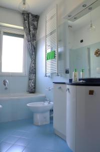 baño blanco con lavabo, bañera y aseo en La casa azzurra en Cogoleto