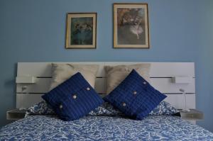 Una cama con dos almohadas azules encima. en La casa azzurra en Cogoleto