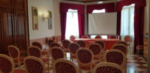 a conference room with a table and chairs and a screen at Hotel Villa Stucky in Mogliano Veneto