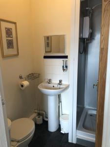 La petite salle de bains est pourvue d'un lavabo et de toilettes. dans l'établissement Leecliff Guest House, à Blackpool