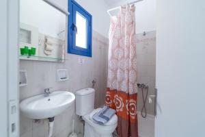 La salle de bains est pourvue d'un lavabo, de toilettes et d'une fenêtre. dans l'établissement Villa Aegeo Studios, à Batsi