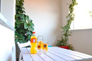 una mesa con dos botellas de zumo de naranja y vasos en La casa azzurra en Cogoleto