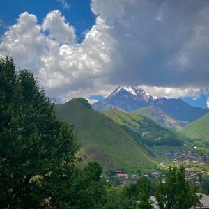 a mountain view of a town in a valley at MOUNTAIN HEART in Kazbegi