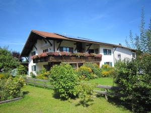 a house with a balcony with flowers on it at Gästehaus Böck in Roßhaupten