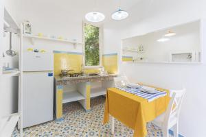 una piccola cucina con tavolo giallo, tavolo giallo e sedia gialla di Le Querce a Procida