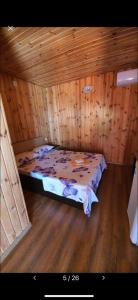 - une chambre avec un lit dans une cabane en bois dans l'établissement Casa Tony si Alex, à Eforie Nord