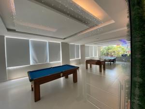 a pool table in a room with two tables at Palladium Refúgio - 500 metros da Praia, Perto do Shopping, Wi-Fi, Piscina e Garagem in São Vicente