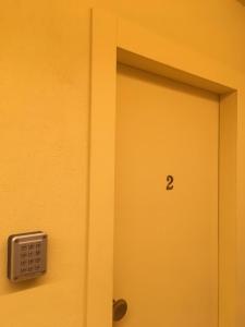 Eine gelbe Tür mit der Nummer zwei drauf. in der Unterkunft 21 Armeno in Neapel