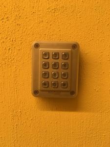 un mando a distancia en un lateral de una pared amarilla en 21 Armeno, en Nápoles