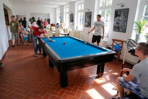 un gruppo di persone che giocano a biliardo in una stanza di Ferienwohnung in der Ciderwirtschaft a Burg Stargard