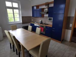 a kitchen with a wooden table and blue cabinets at Ferienwohnung in der Ciderwirtschaft in Burg Stargard