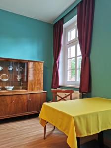 una camera da letto con tavolo giallo e cassettiera di Ferienwohnung in der Ciderwirtschaft a Burg Stargard