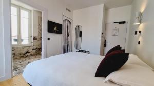 a white bedroom with a white bed and a window at Boutique Hotel Nice Côte d'azur in Nice