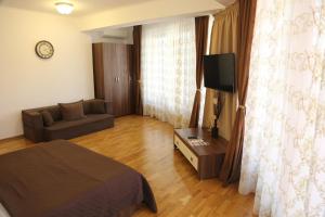 a bedroom with a bed and a couch and a television at AnaMaria Apartments Mamaia Nord in Mamaia Sat/Năvodari