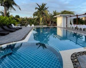 a large swimming pool with blue tiles in a resort at Baan Thai House in Phra Nakhon Si Ayutthaya