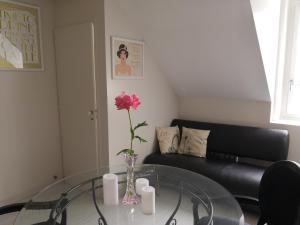 a living room with a glass table with a flower in a vase at Cosy Aix in Aix-les-Bains