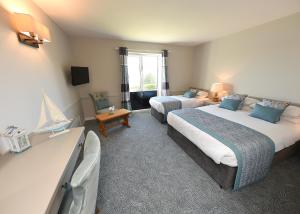 um quarto de hotel com duas camas e uma televisão em Whispering Pines em Crosshaven