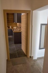 a kitchen with a door leading into a kitchen with a counter at Apartman Joso 2 in Sukošan