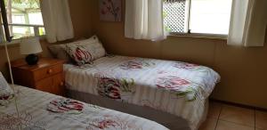 a bedroom with two beds and a window at Nature's Cottage in Hibberdene