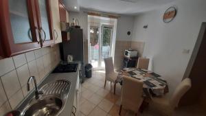 a kitchen with a sink and a table and a kitchen with a table at Apartman Pio in Senj