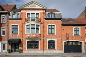 un bâtiment en brique rouge avec un panneau de marquage dans l'établissement Hôtel *** Maraboe, à Bruges