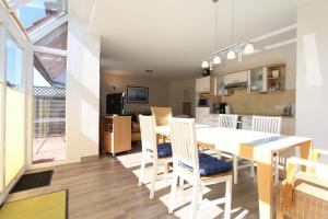 une salle à manger et une cuisine avec une table et des chaises dans l'établissement DHH Welle, à Kellenhusen