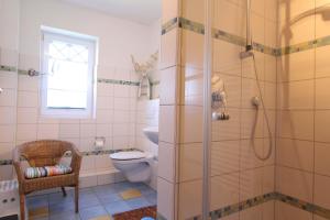 une salle de bain avec douche et toilettes et une fenêtre dans l'établissement DHH Welle, à Kellenhusen 8 autres photos