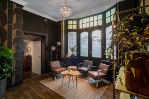 a living room with chairs and a table and a window at Hotel Maraboe in Bruges