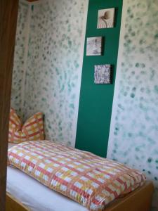a bedroom with a bed with a green wall at Pension zur Einkehr in Allersberg