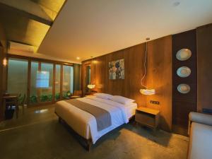 a bedroom with a large bed and some windows at Tekuni 2 in Legian
