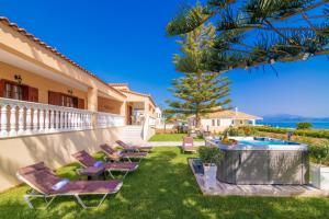 a backyard with chairs and a swimming pool at Sea Elegance Villa in Zakynthos Town