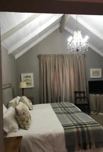 a bedroom with a large bed and a chandelier at Critchley Hackle - Tower rooms in Dullstroom +9 photos