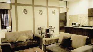 a living room with couches and a table and a kitchen at Al Fawanes Hotel Apartments in Amman