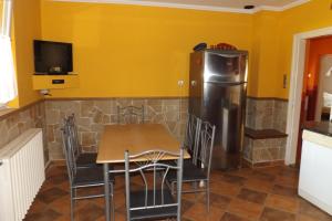 a dining room with a table and a refrigerator at Napsugár Vendégház in Keszthely