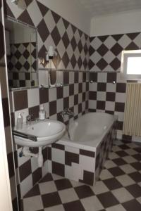 a bathroom with a sink and a bath tub at Napsugár Vendégház in Keszthely